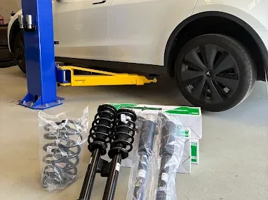 New suspension parts ready to fit on a car in the workshop