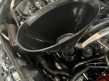 Oil being poured into an engine during maintenance
